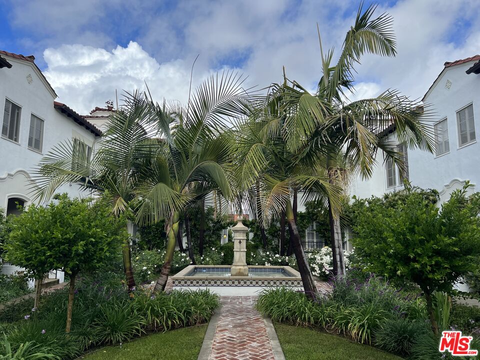 a front view of a house with a yard and potted plants