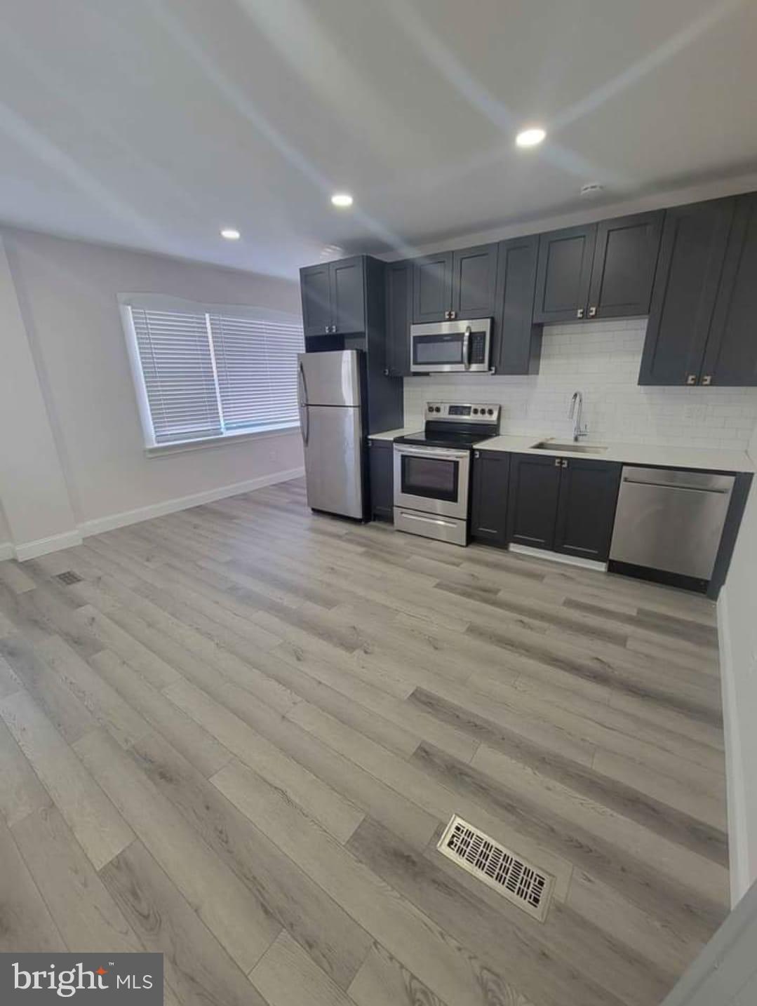 a large kitchen with kitchen island a sink stainless steel appliances and cabinets