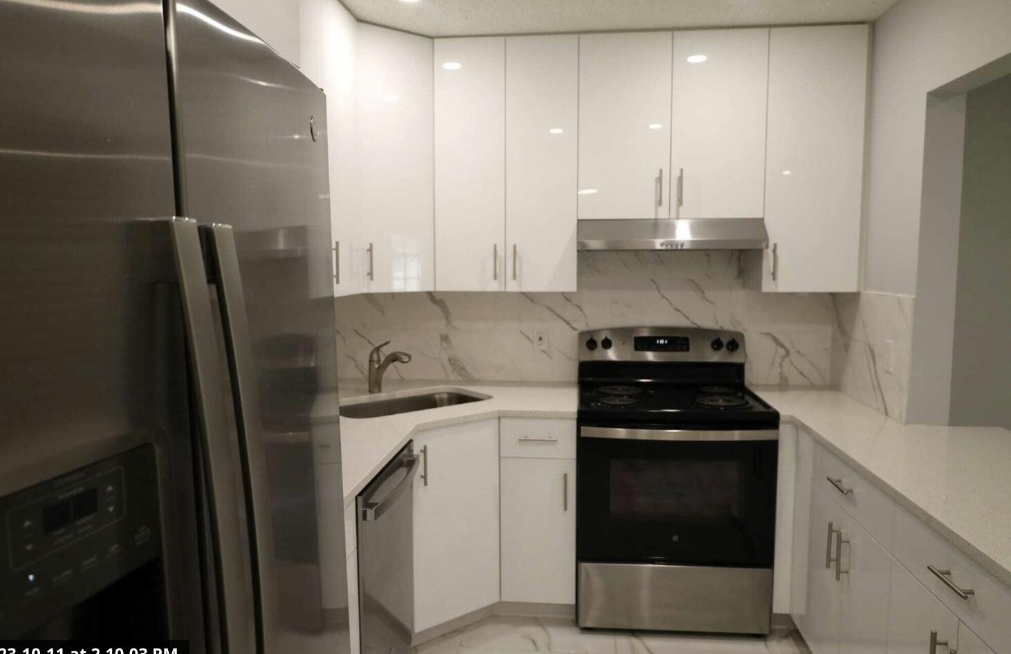 a kitchen with stainless steel appliances granite countertop a stove a refrigerator and a sink