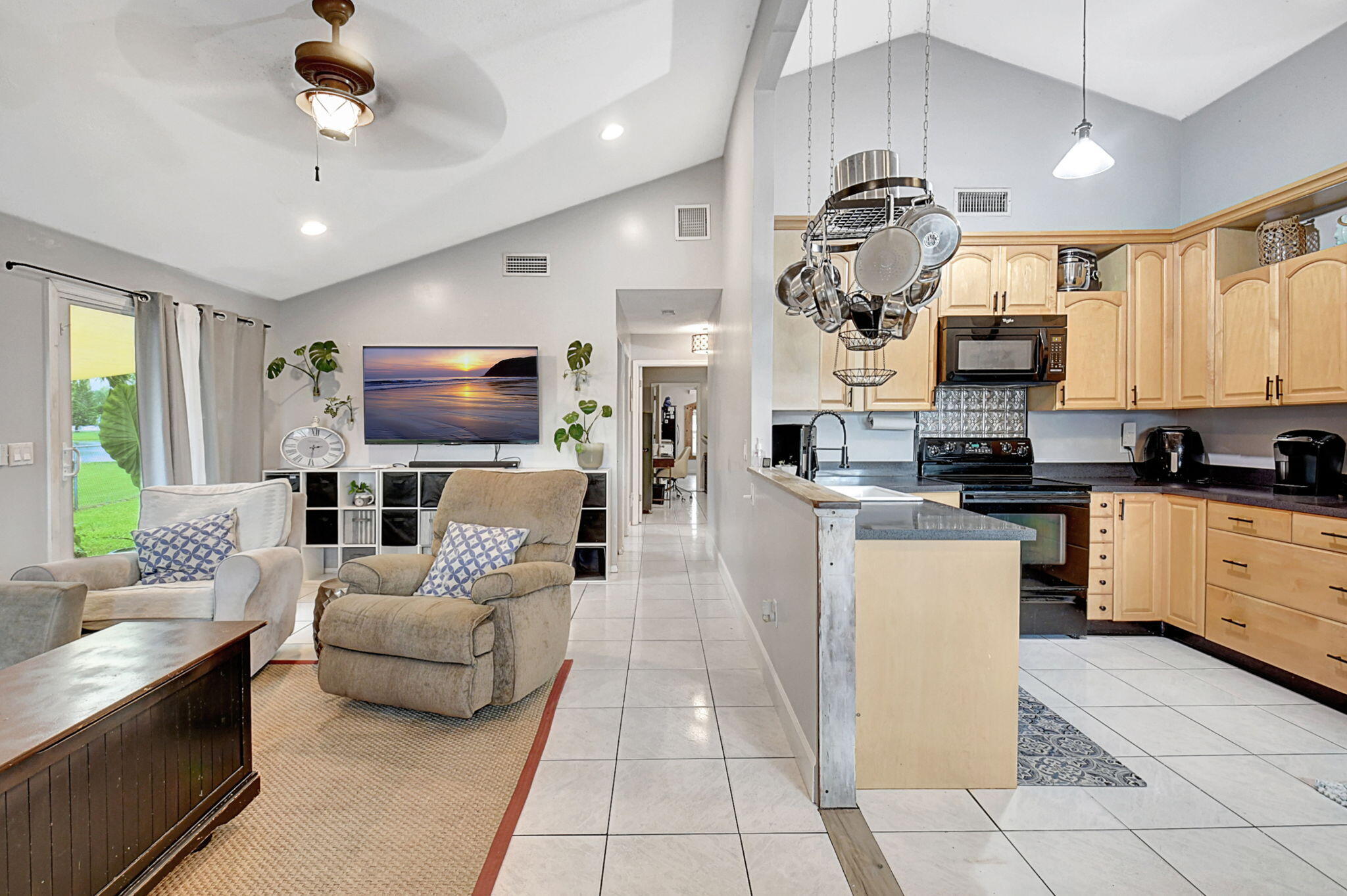 a living room with furniture a chandelier and a flat screen tv