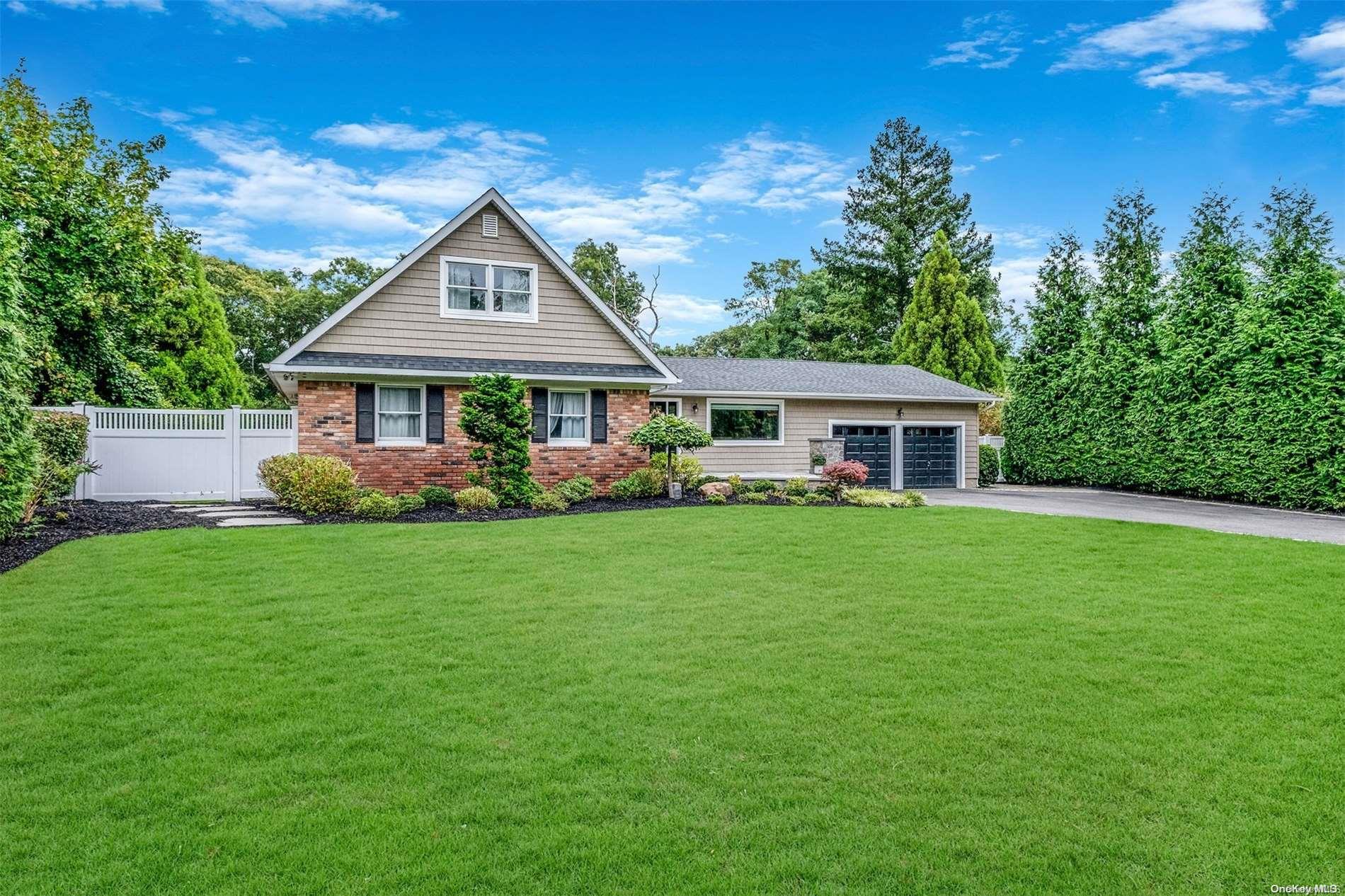 a front view of a house with a yard and green space