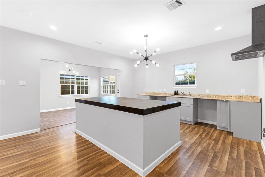 a kitchen with granite countertop a sink cabinets and wooden floor