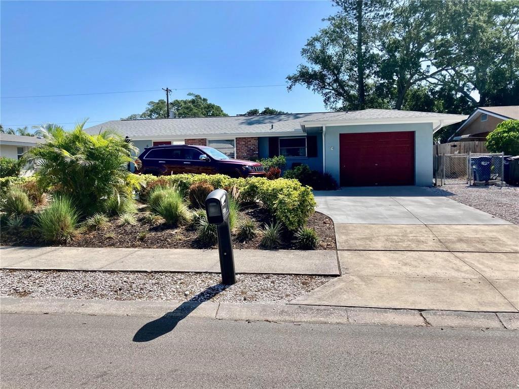 a front view of house with yard space and car parked