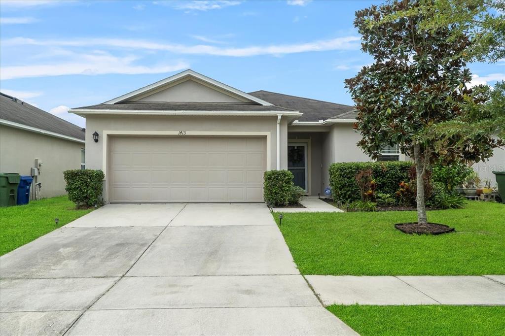 a front view of a house with a yard and trees