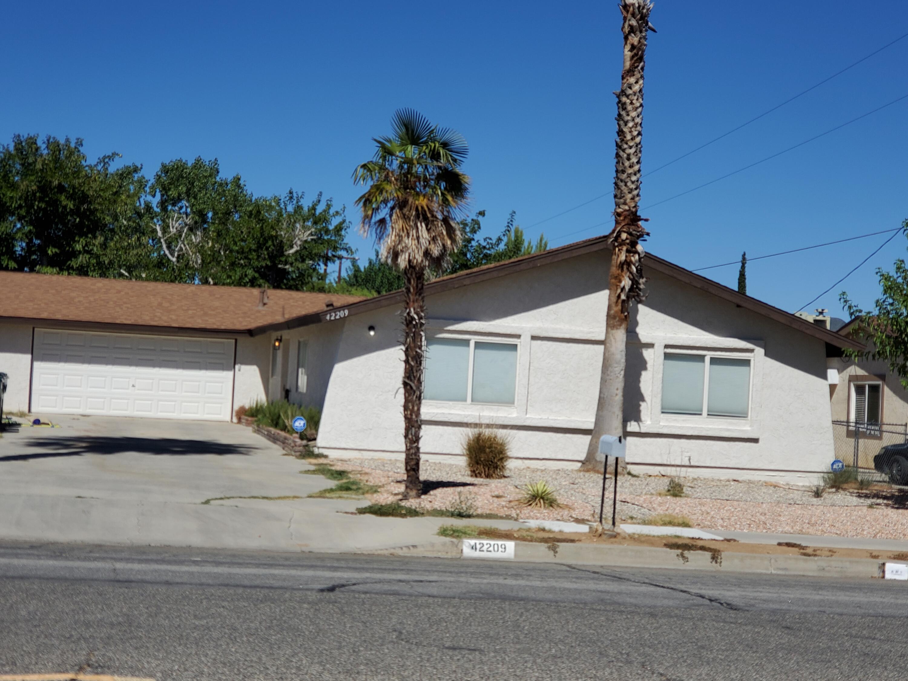 a front view of a house with a tree