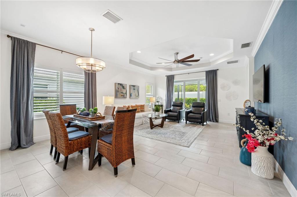 a view of a dining room and livingroom with furniture wooden floor a chandelier