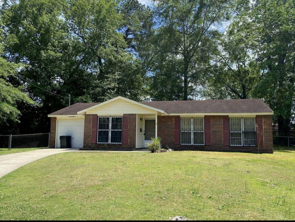 a front view of house with yard and trees around