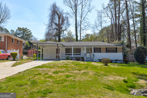 a front view of a house with yard and green space