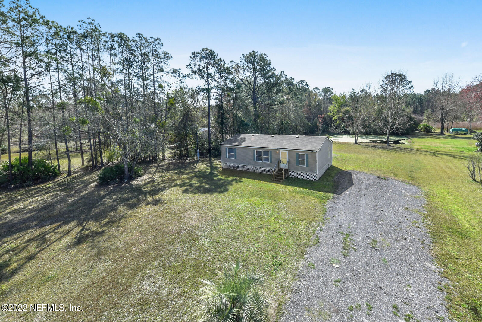 a view of a house with backyard and trees