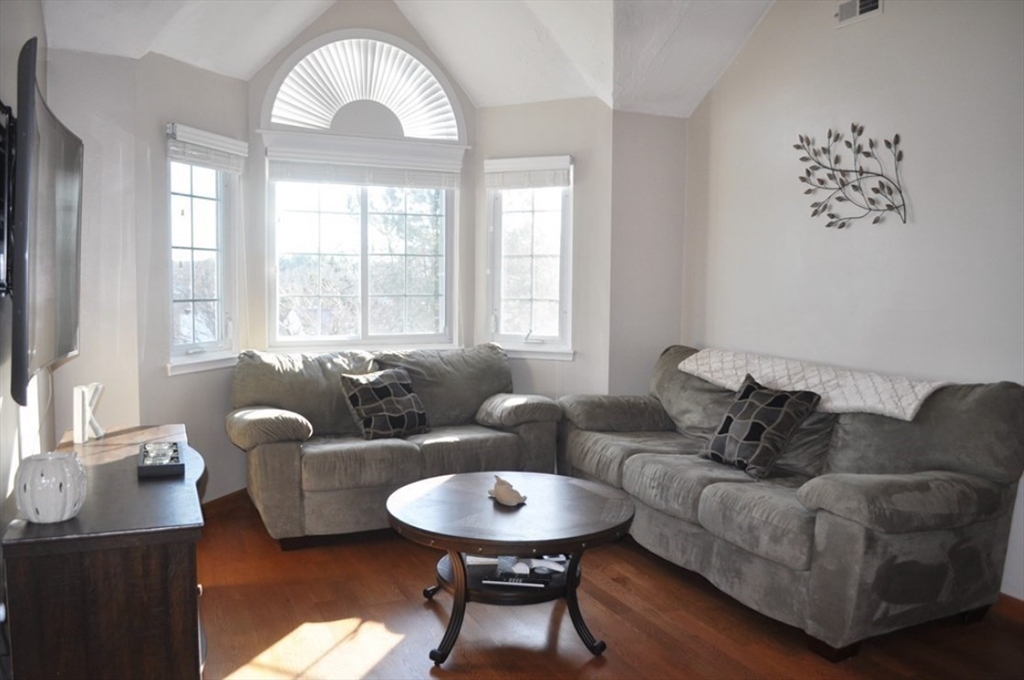 a living room with furniture a large window and a chandelier