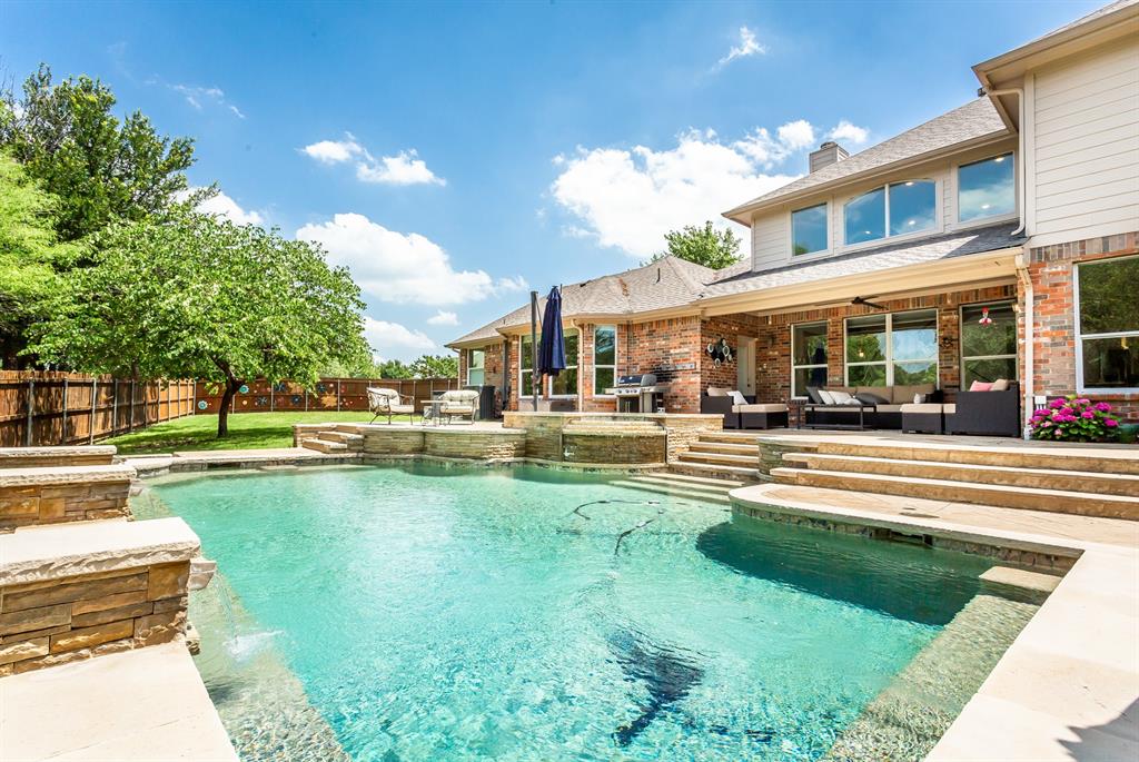 a front view of a building with a garden and swimming pool