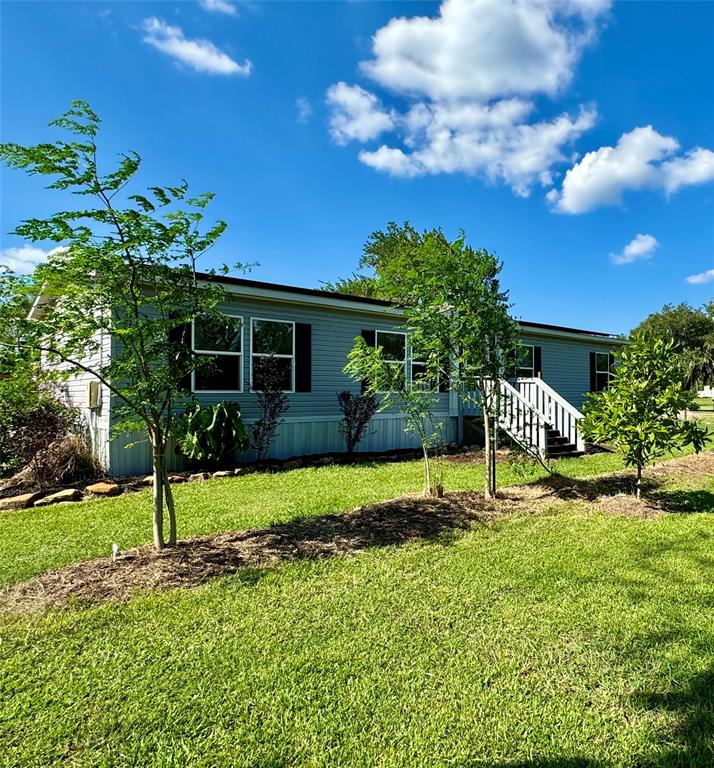 a view of a house with a yard and a garden