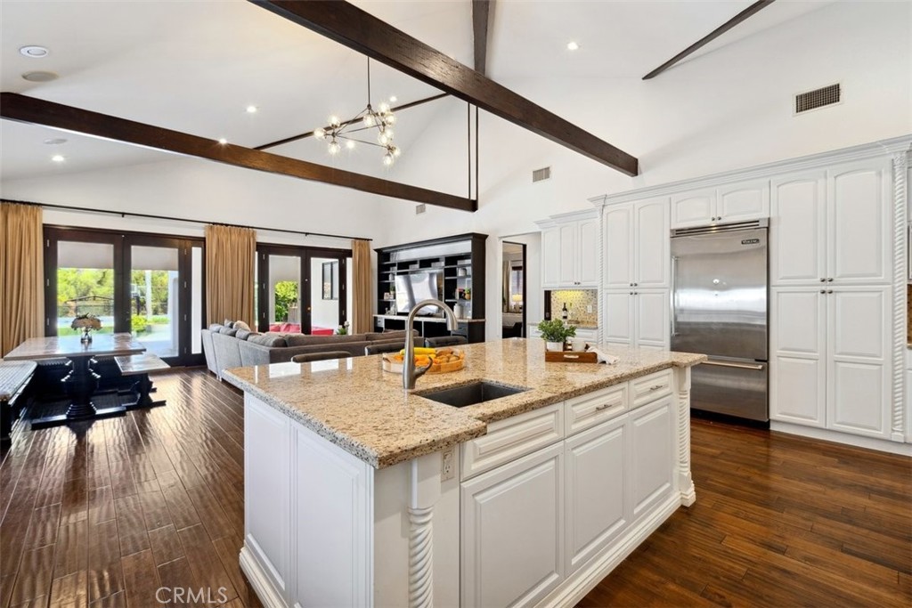 a kitchen with stainless steel appliances granite countertop a lot of counter space and wooden floors