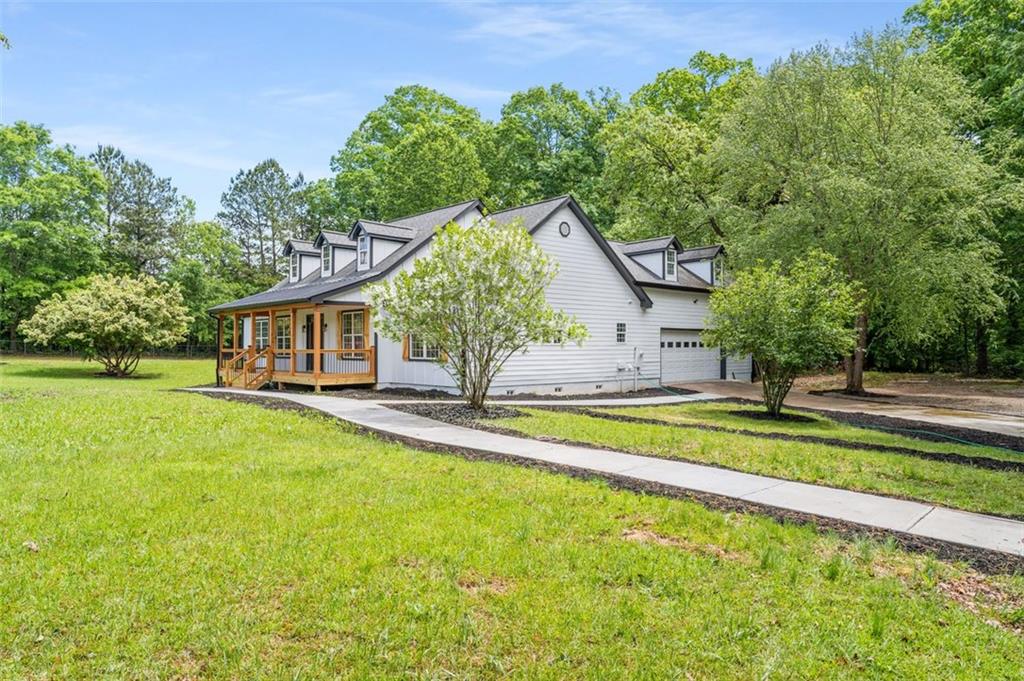 a view of a house with pool and a yard