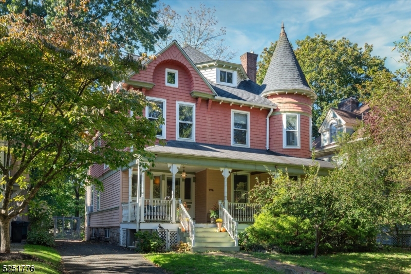 a front view of a house with a yard and potted plants