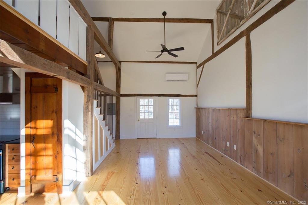 a view of hallway with stairs and wooden floor