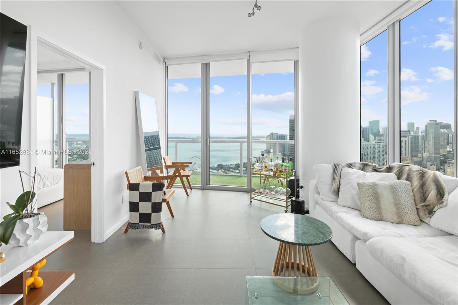 a living room with furniture and floor to ceiling windows