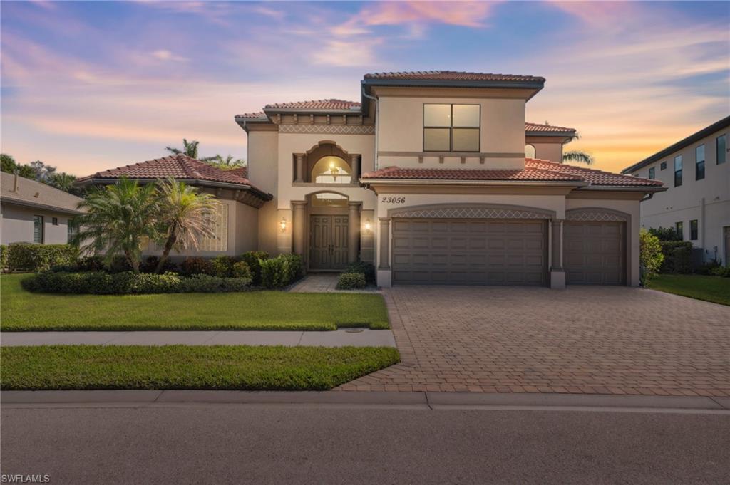 Mediterranean / spanish-style house featuring a lawn and a garage