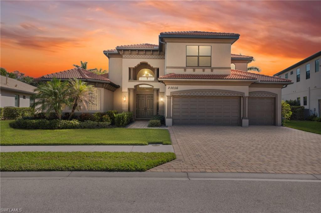 Mediterranean / spanish-style home featuring a garage and a yard