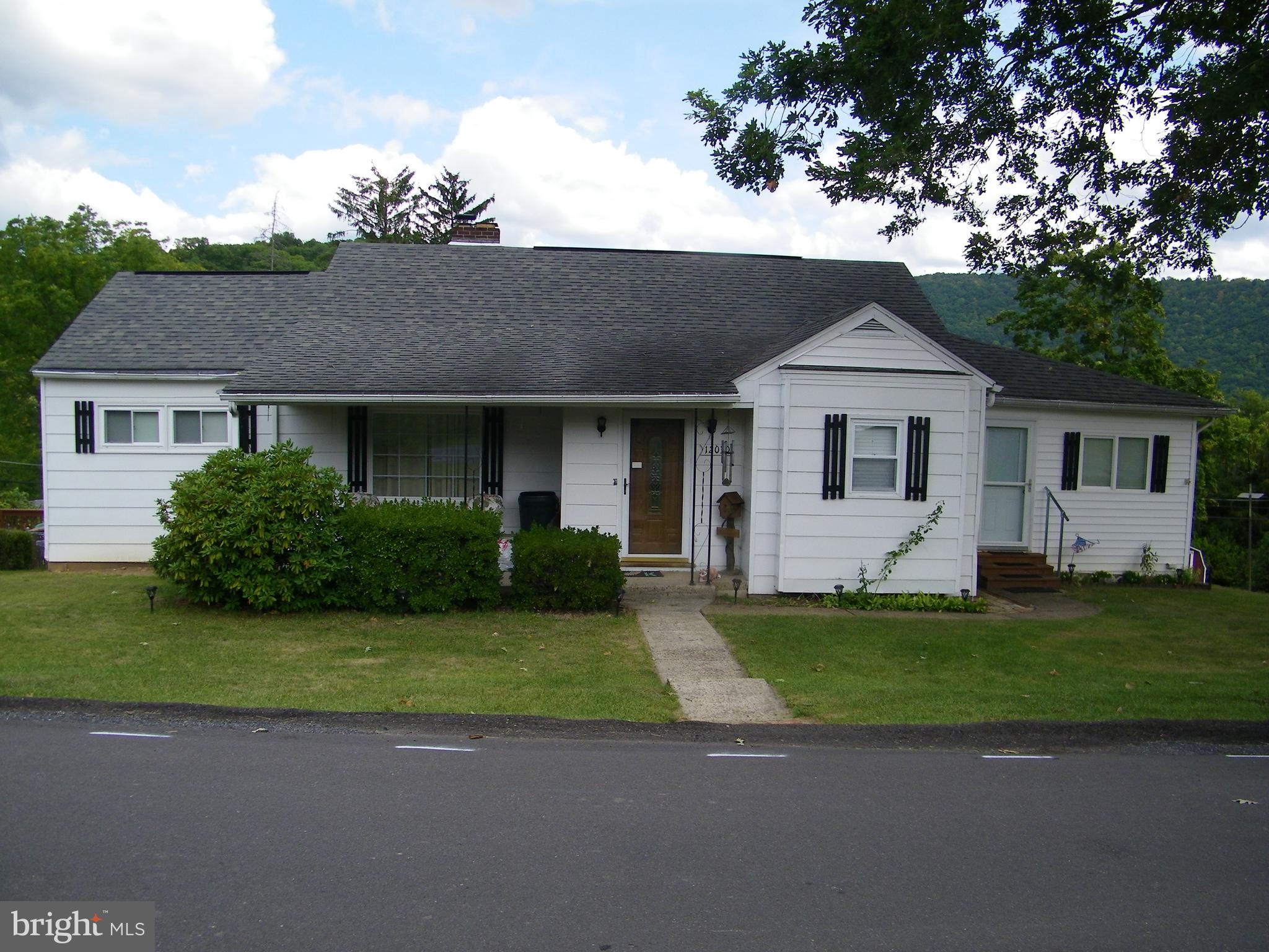 a front view of a house with a garden and yard