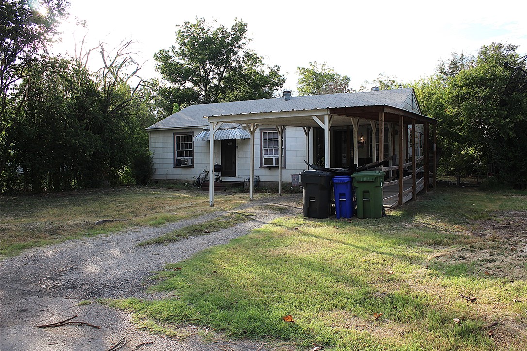 a view of a house with backyard and trees