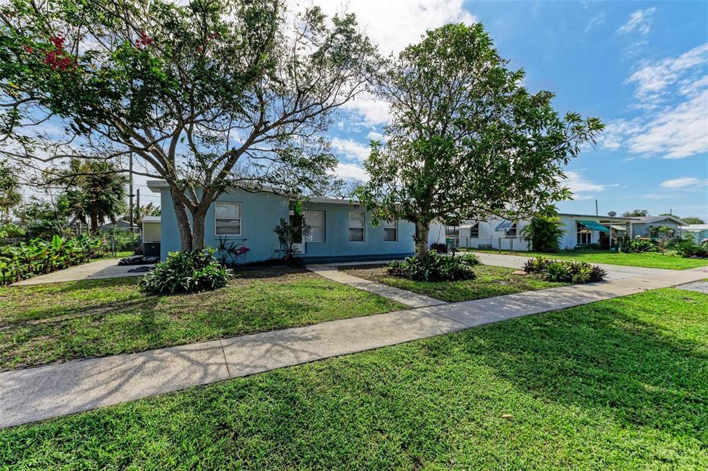 a view of a house with backyard and a tree