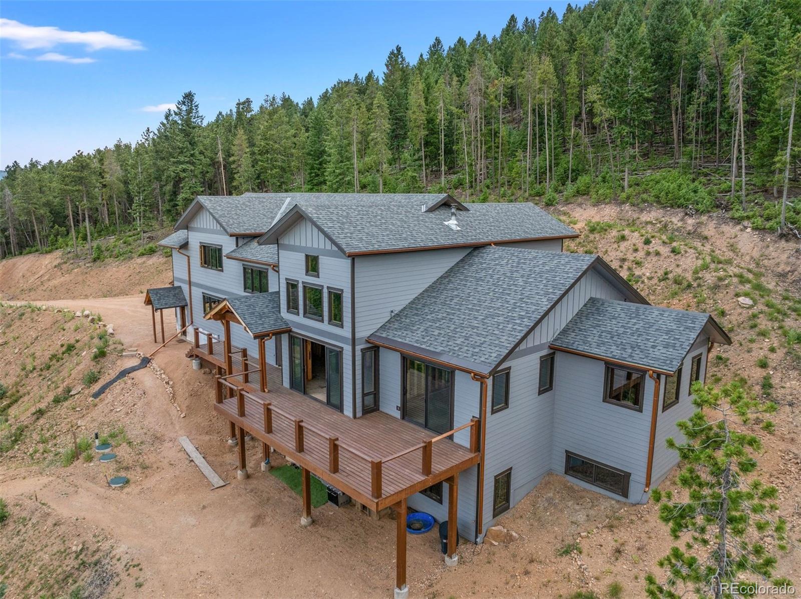 aerial view of a house with a yard and mountain view in back