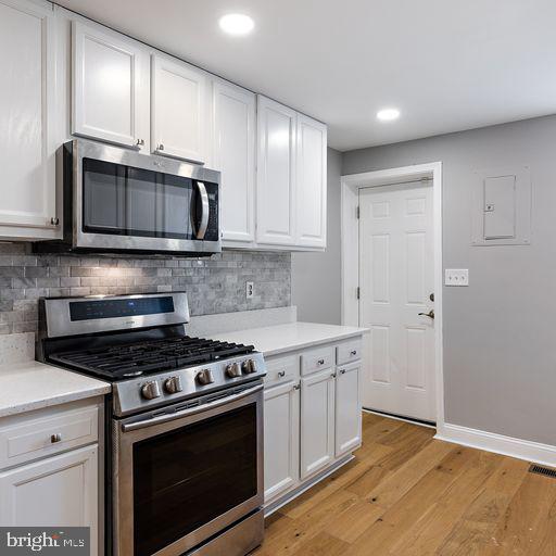 a kitchen with granite countertop cabinets stainless steel appliances and wooden floor