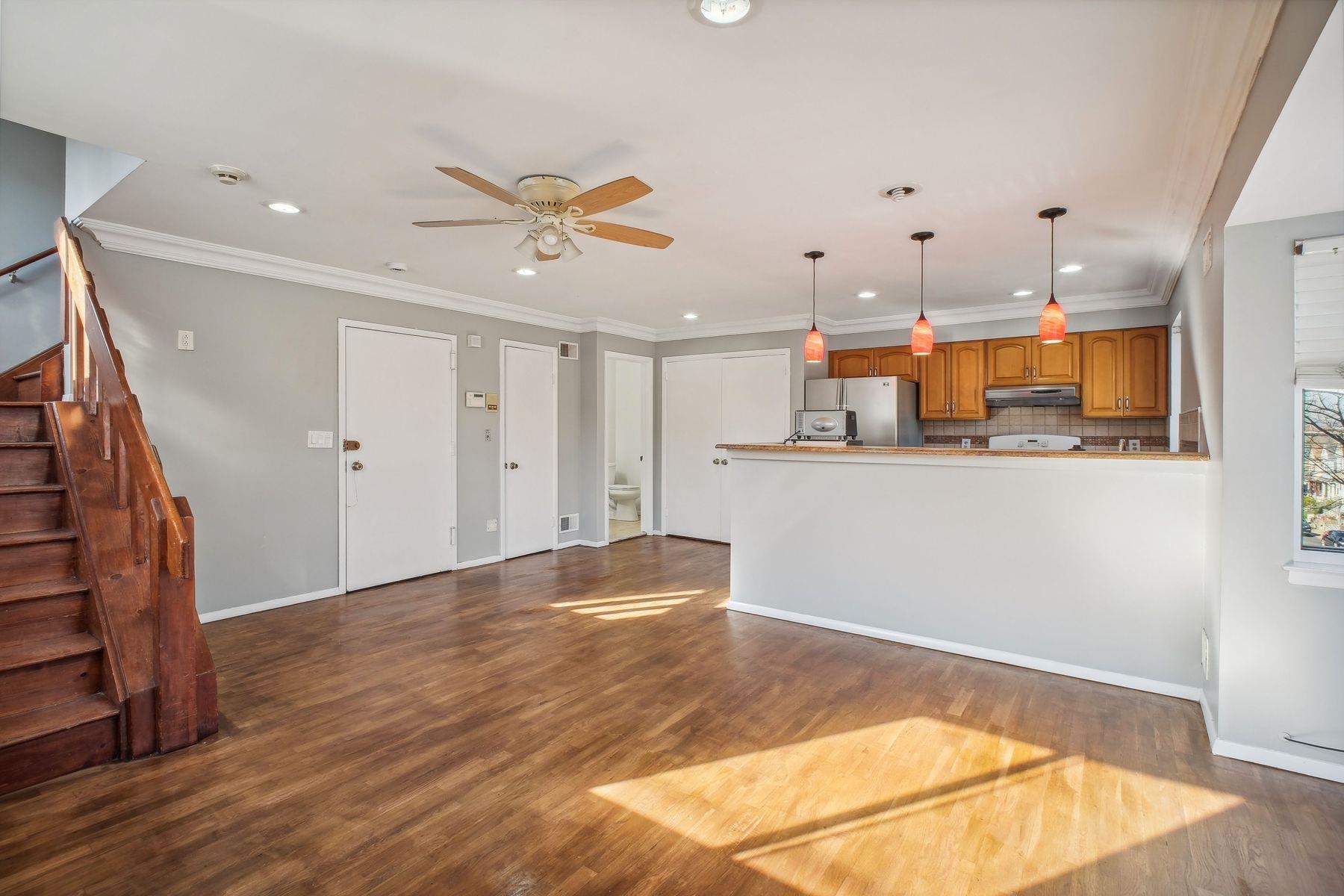 a view of a kitchen with wooden floor and staircase