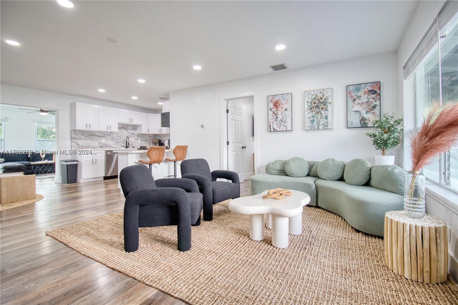 a living room with furniture and a view of kitchen