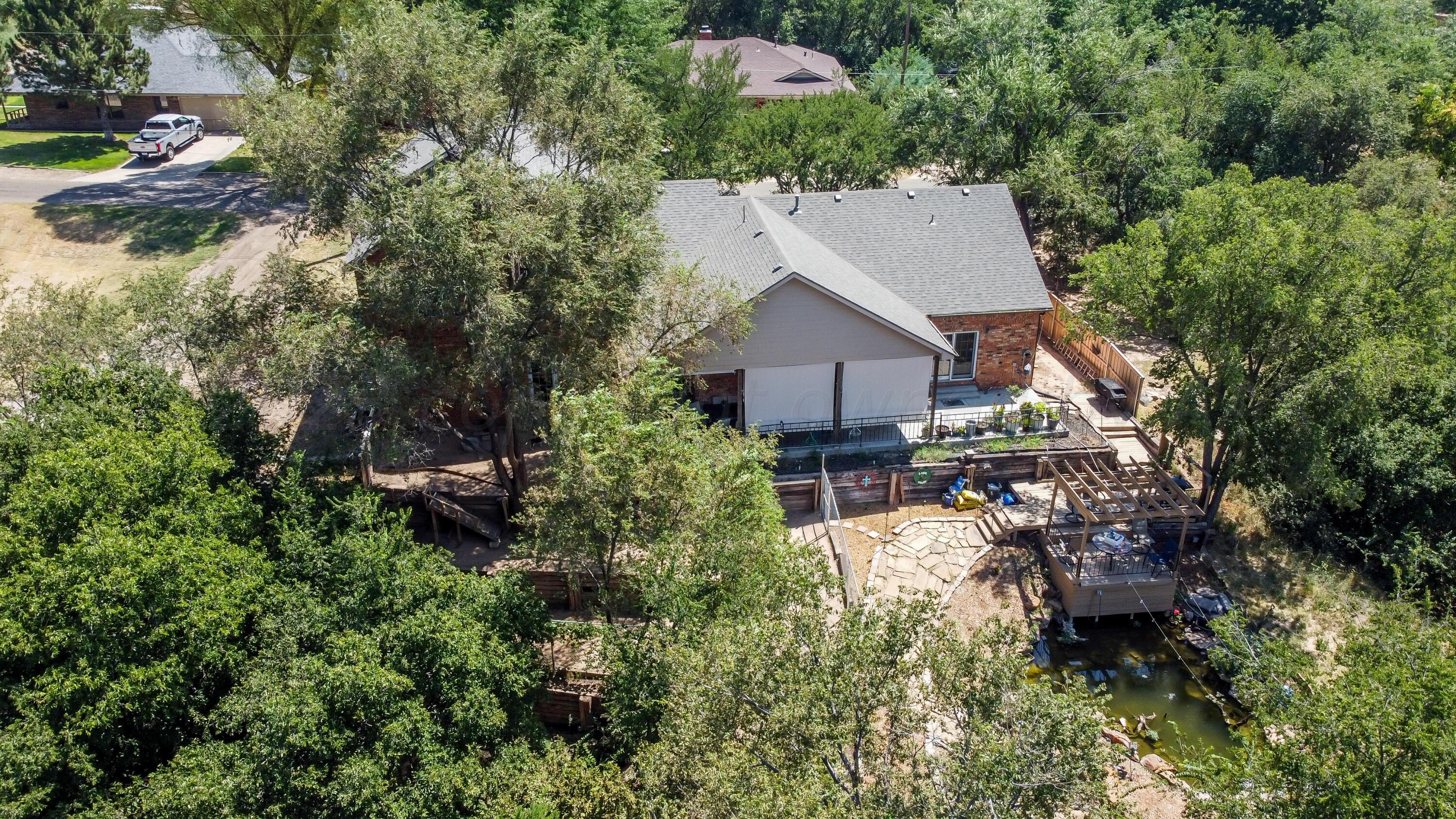 an aerial view of a house with a yard and trees