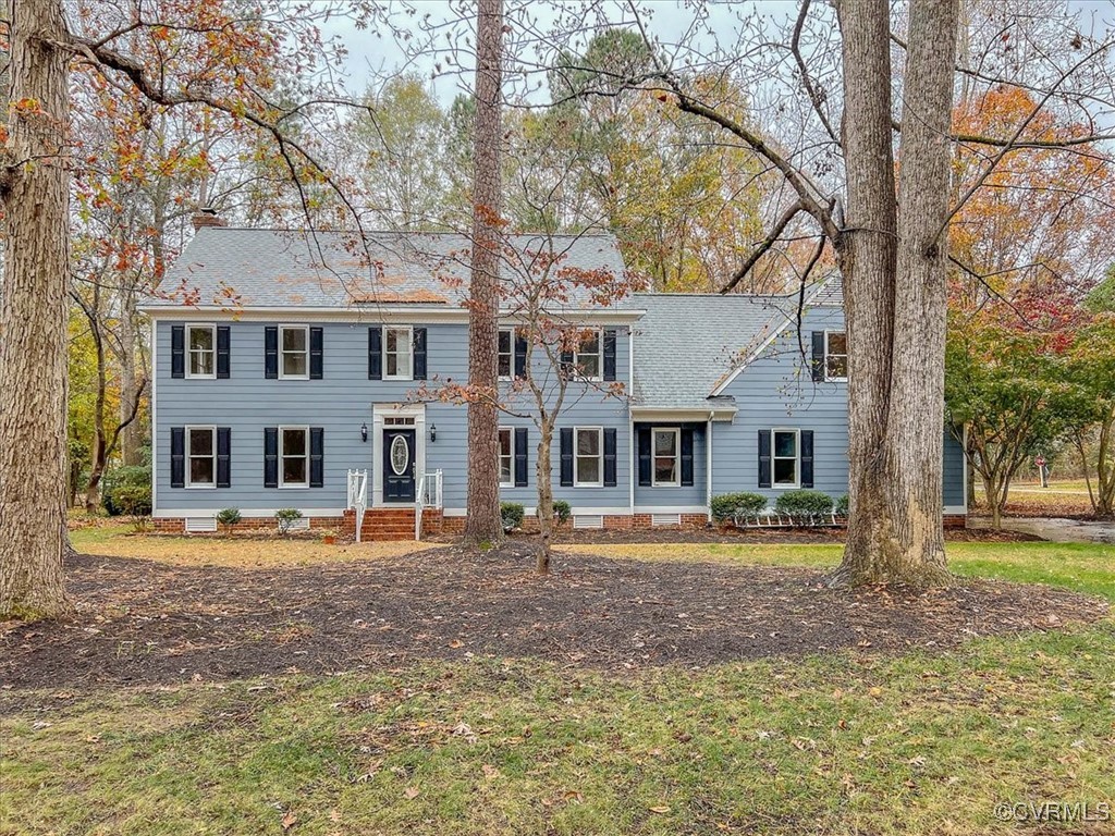 Colonial inspired home featuring a front lawn