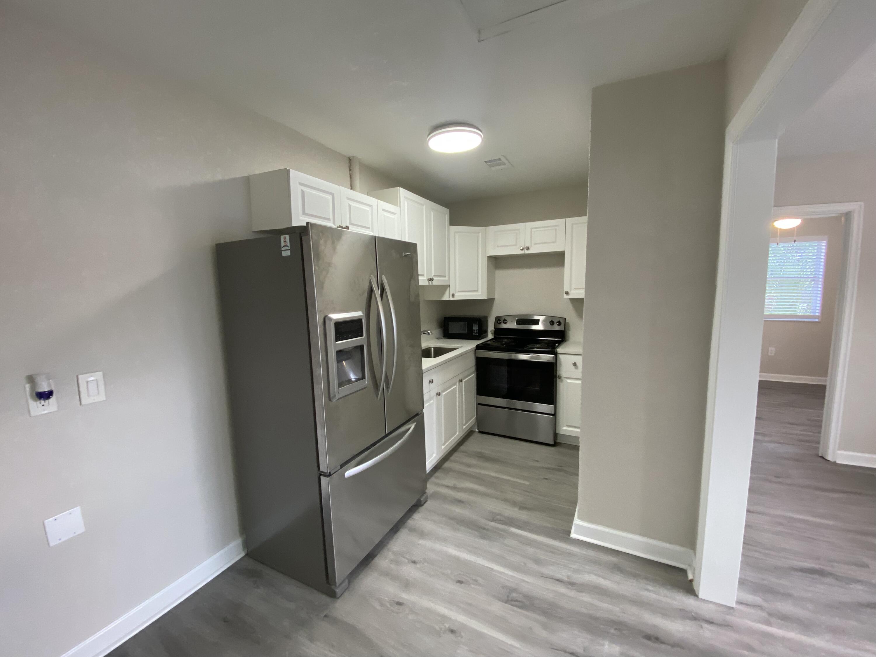 a kitchen with granite countertop a refrigerator and a sink