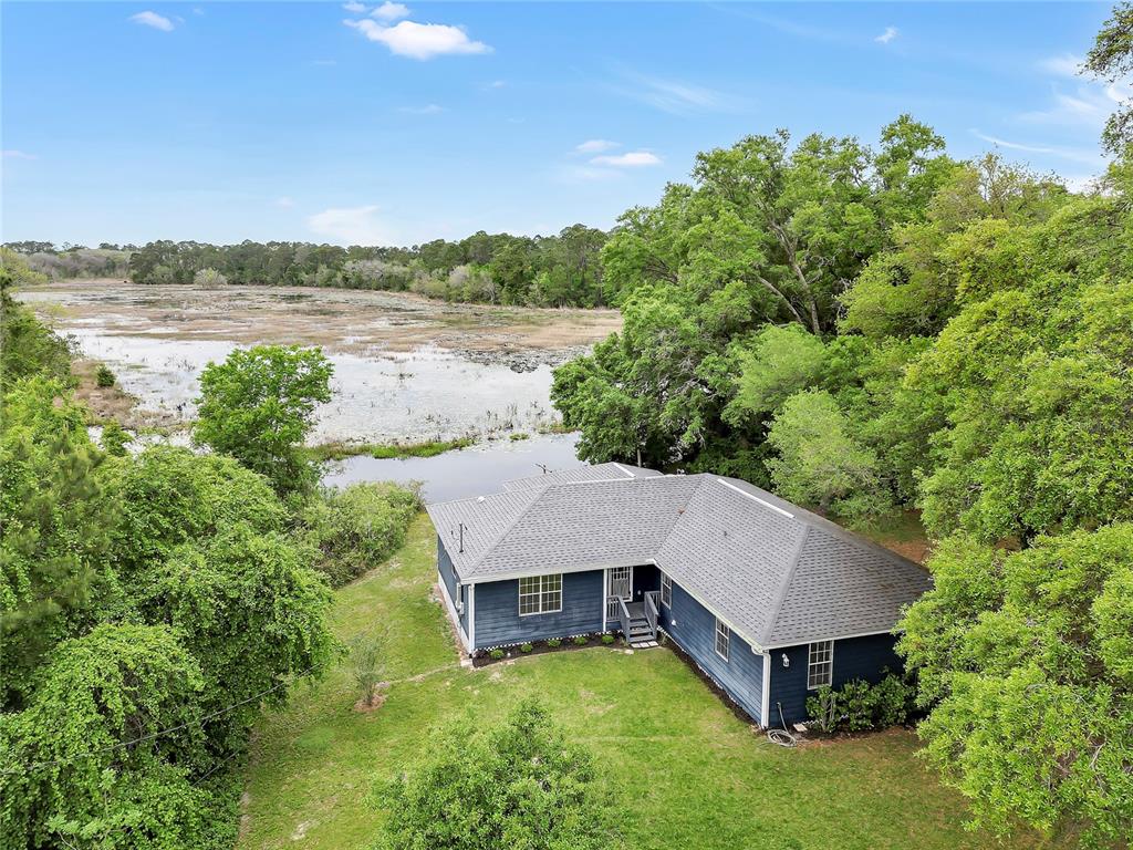 an aerial view of a house with yard and lake view