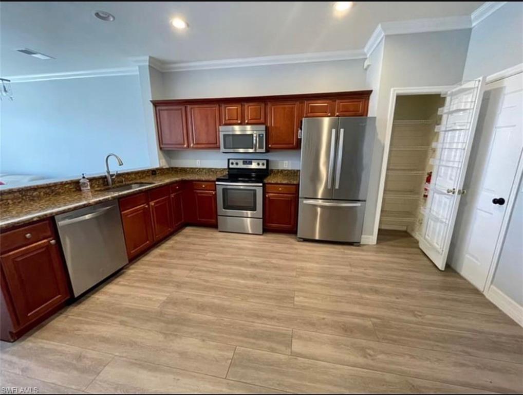 a large kitchen with stainless steel appliances granite countertop a refrigerator and a sink