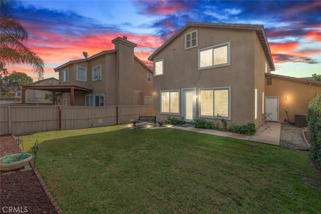 The spacious backyard offers ample room for entertaining, complete with a cozy seating area and plenty of greenery for relaxation.