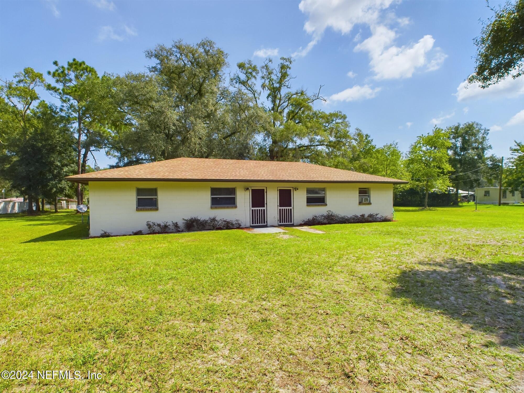 a front view of house with yard and trees