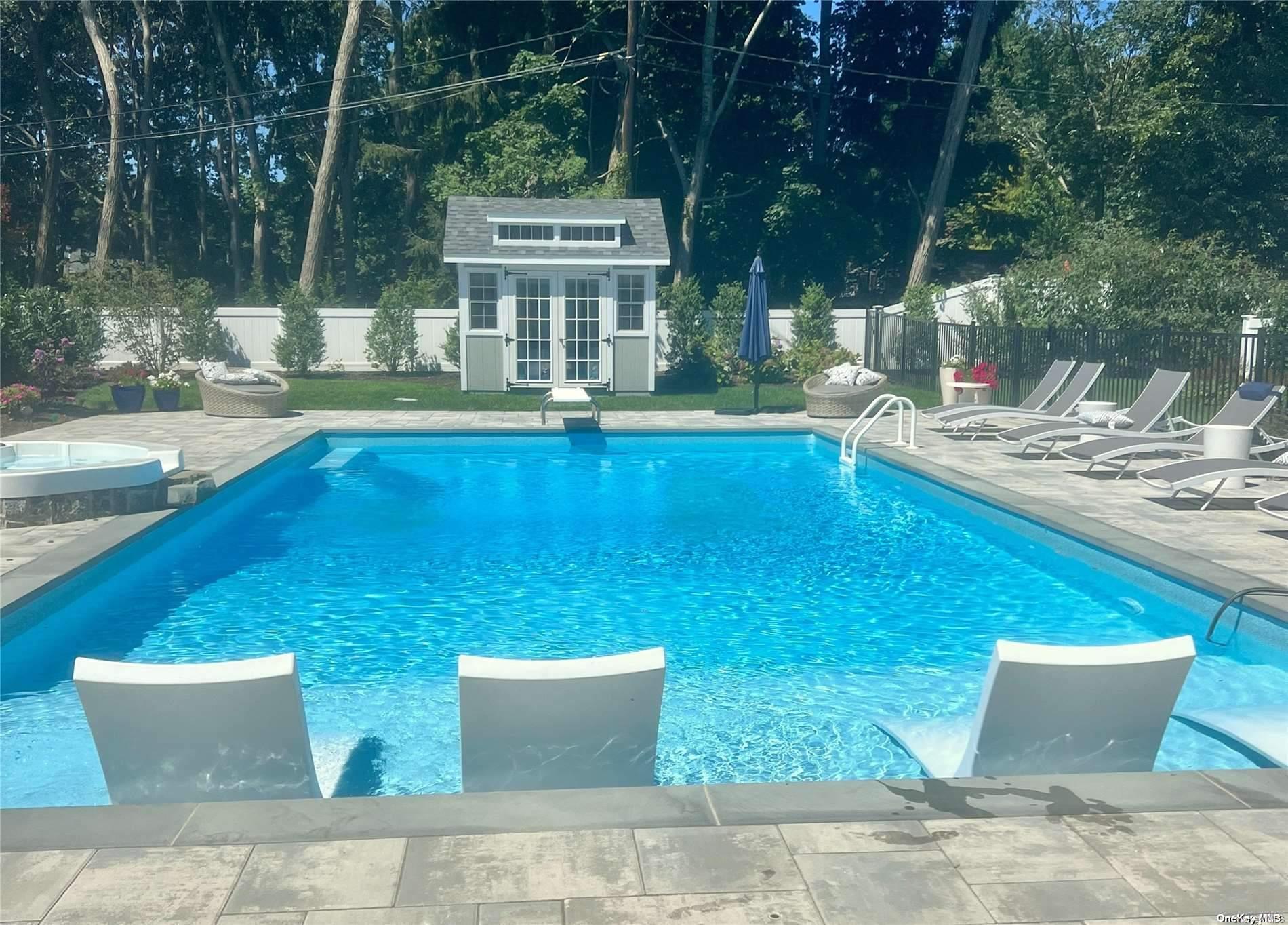 a view of a house with pool and chairs