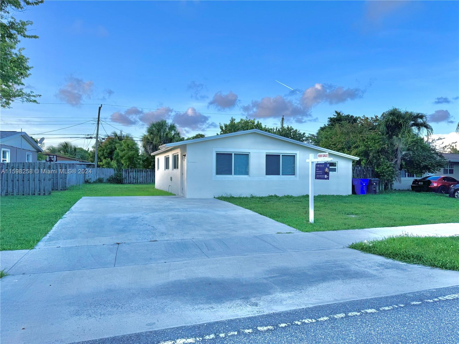 a view of an house with backyard and a tree