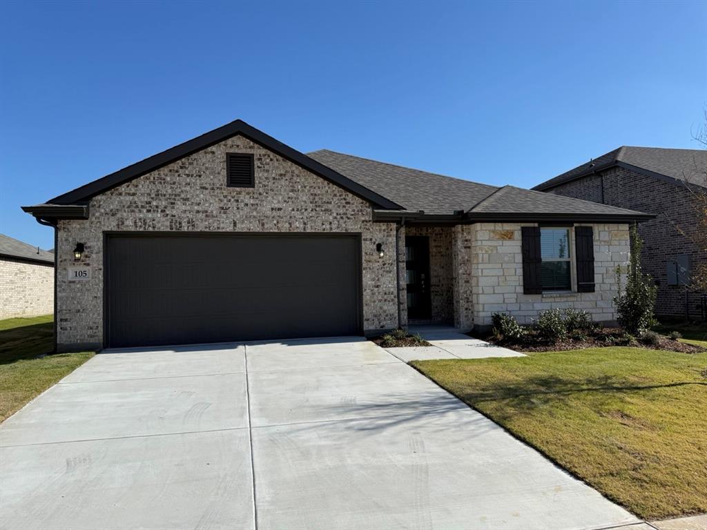 a front view of a house with yard and garage