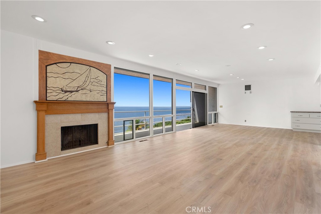 a view of an empty room with a fireplace and window