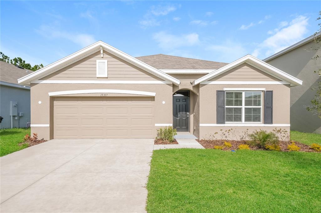 a front view of a house with a yard and garage