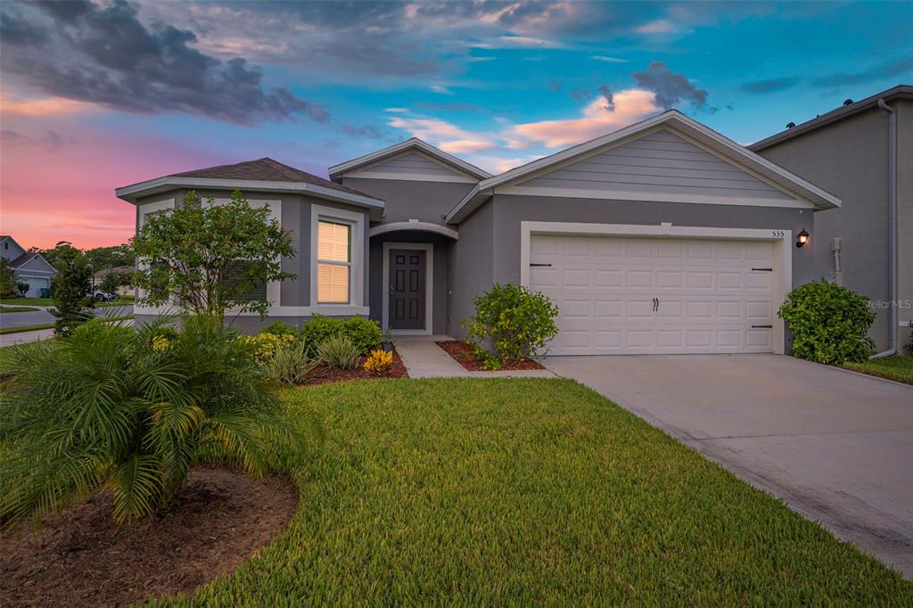 a front view of a house with a yard and garage