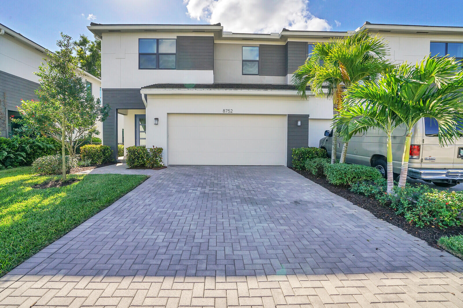 a front view of a house with a yard and a garage