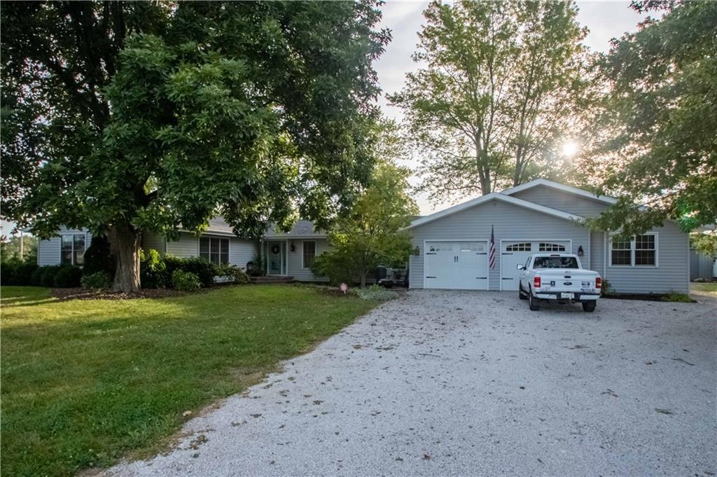 a view of a house with a yard and large trees