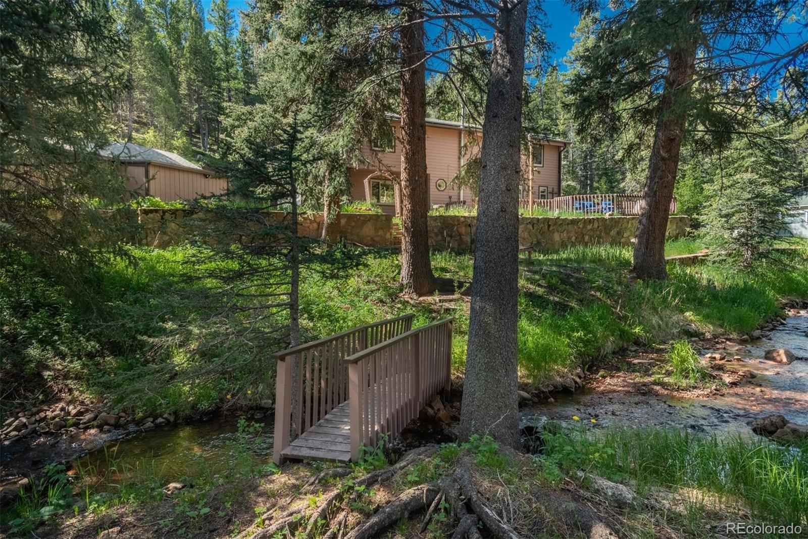 a view of a pathway of a house with a tree in the yard