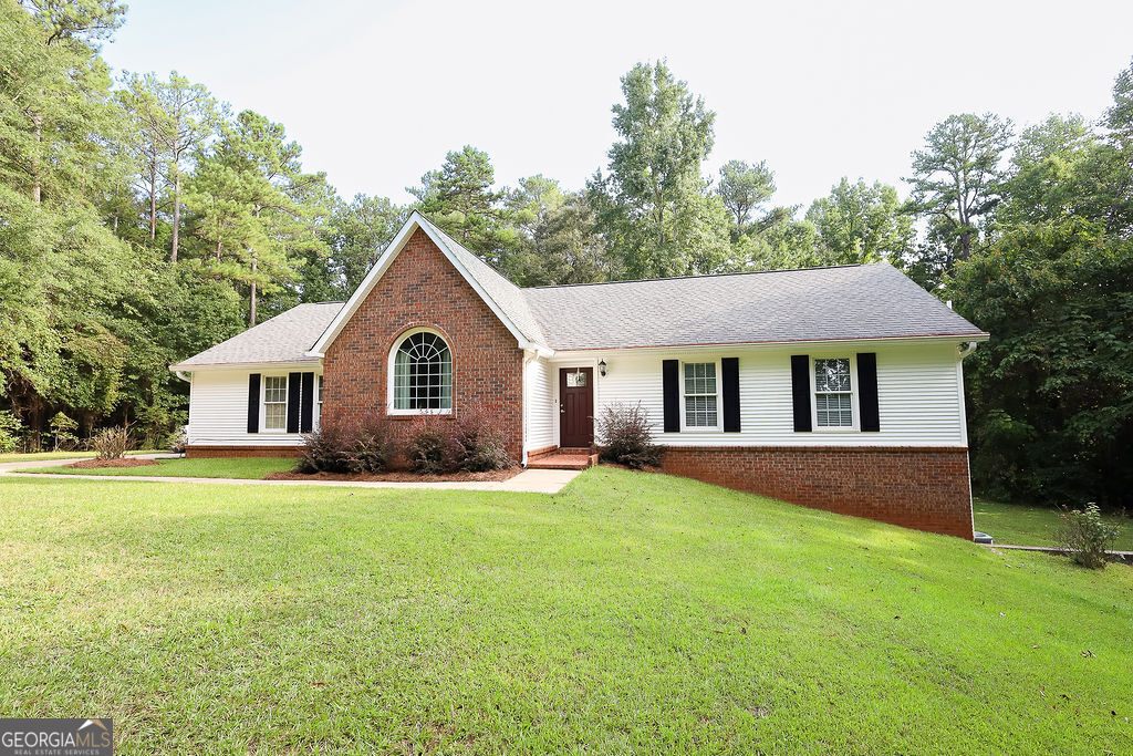 a front of a house with a garden and trees