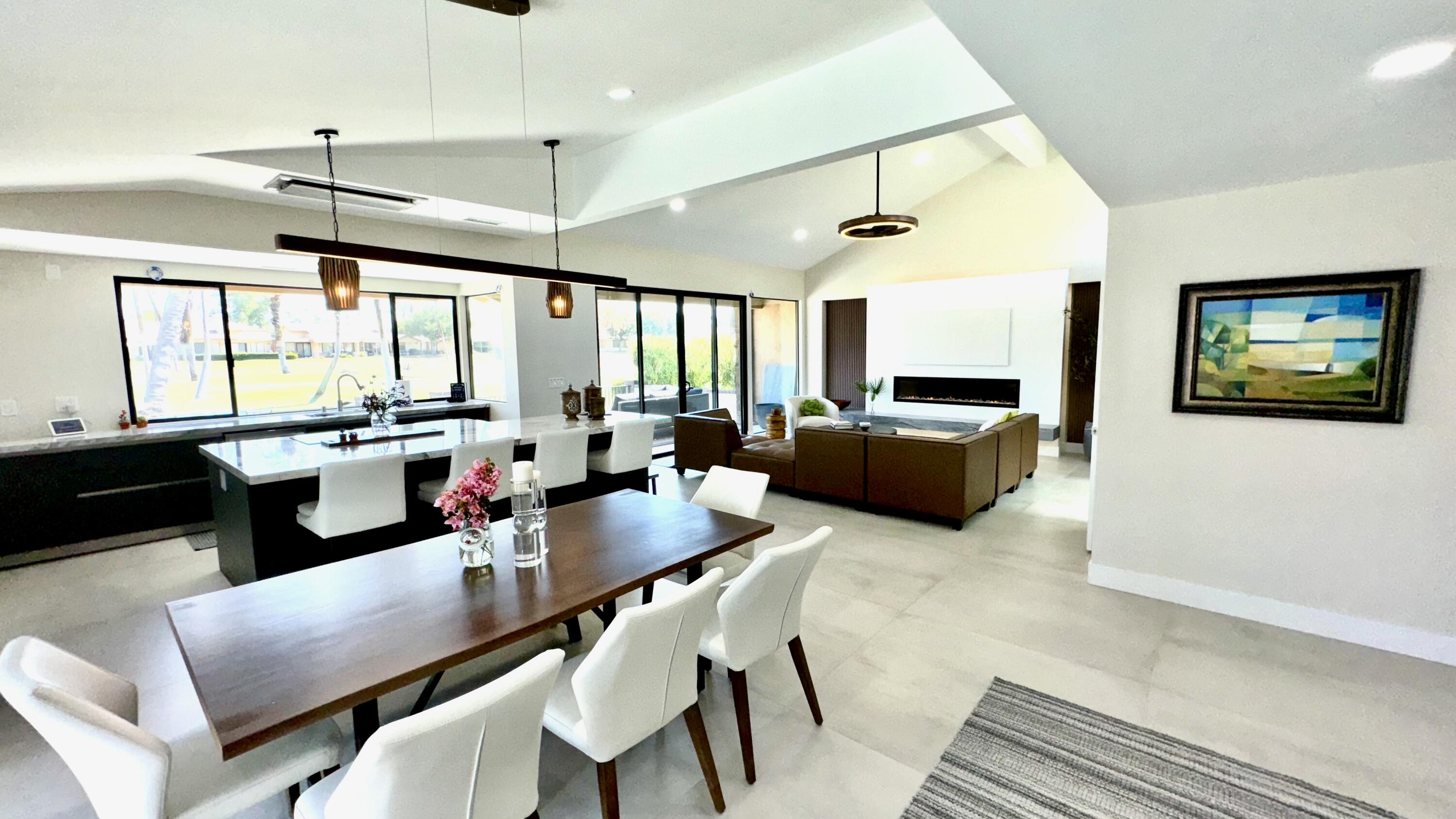 a living room with furniture a flat screen tv and a large window