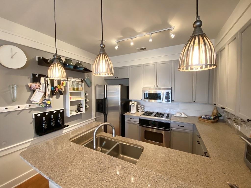 a kitchen with stainless steel appliances granite countertop a sink a stove and a refrigerator