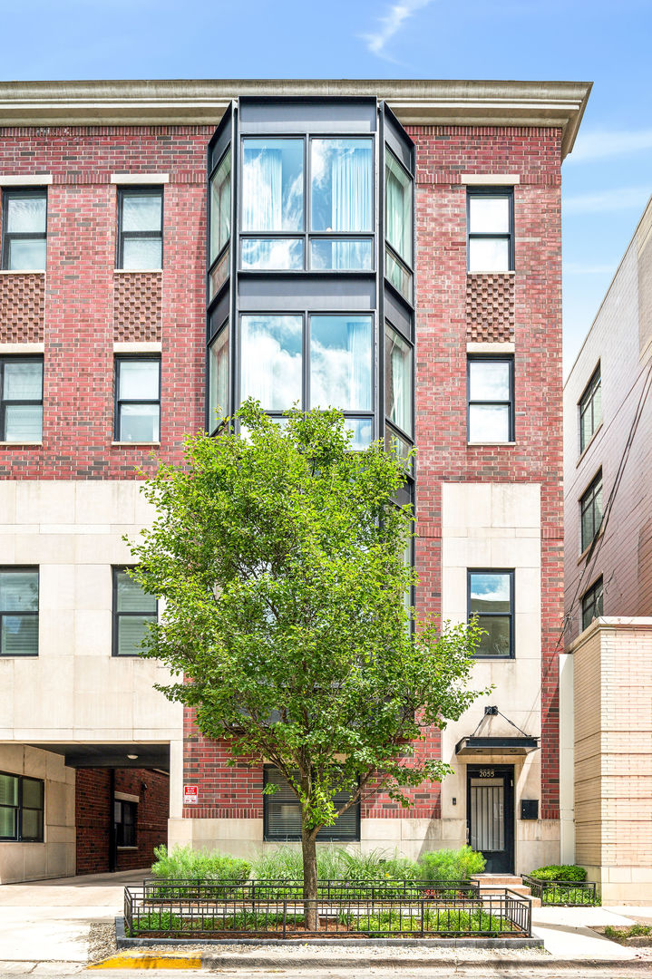 a front view of a residential apartment building with a yard